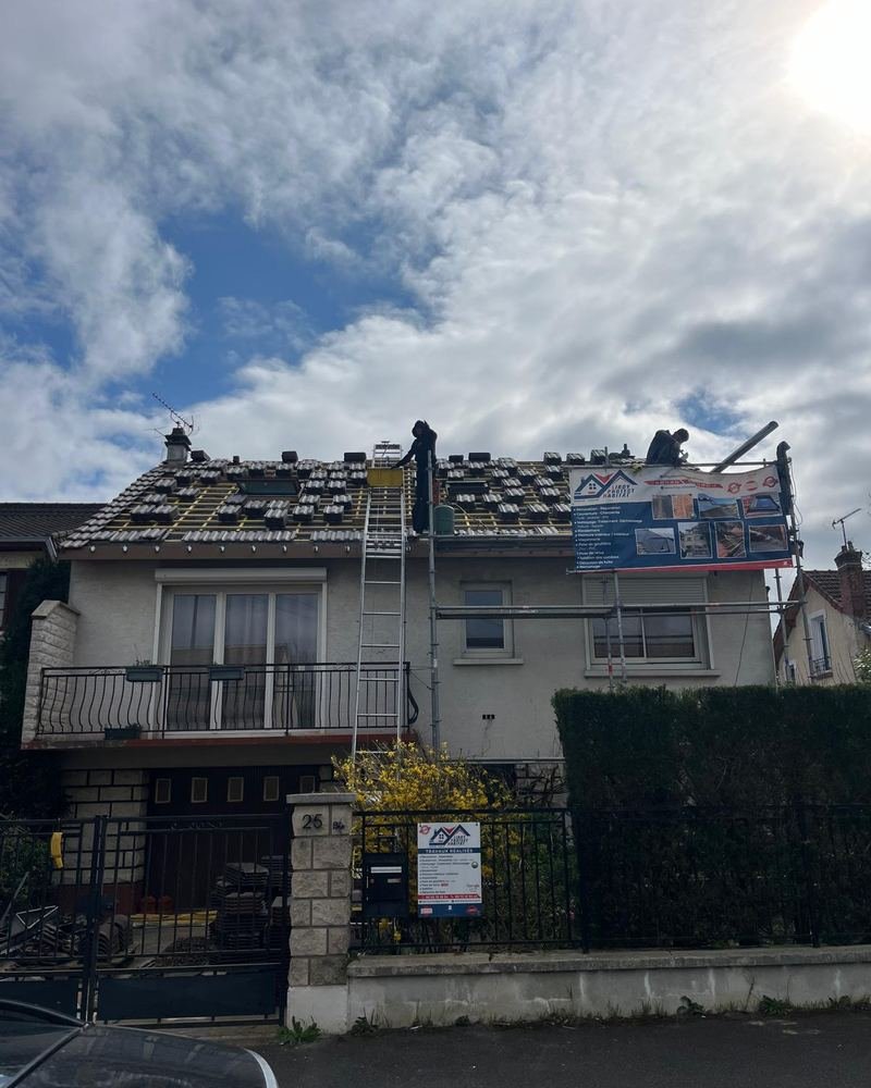 Dépose des tuiles d'une toiture pavillonnaire depuis un échafaudage de couvreur