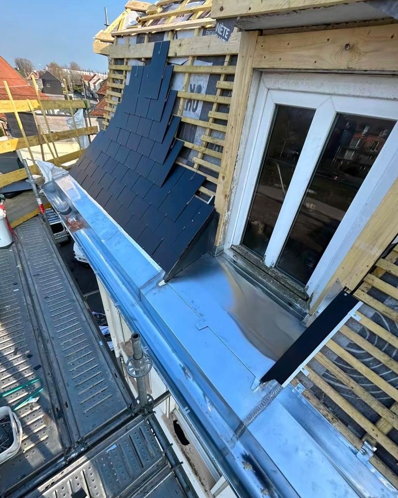 Lucarne habillée en ardoise avec joues en zinc et gouttière zinc en pied de versant