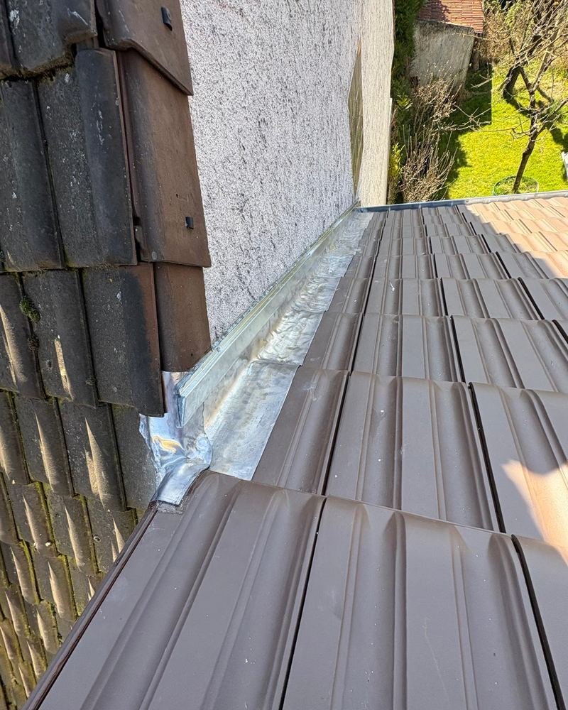 Solin en zinc encastré contre un mur mitoyen, le long d'une couverture en tuiles